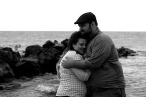 Michelle and her husband at the beach on Lake Erie taking engagement pictures
