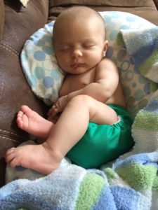 Baby in a cloth diaper laying on a Boppy pillow