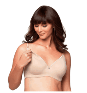 A brunette woman undoing the snap on a nude colored nursing bra